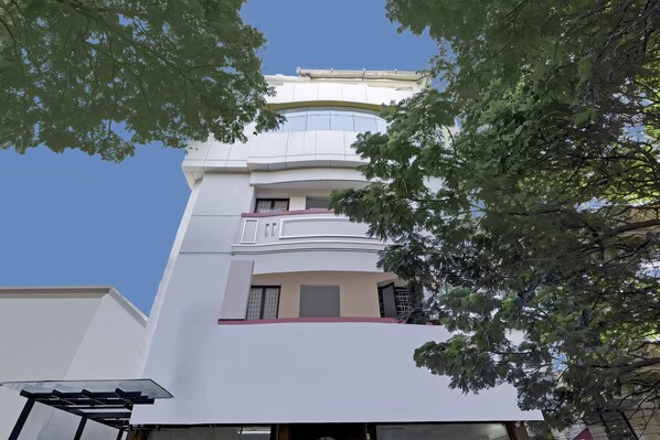 A multi-story building with a modern architectural design, featuring balconies and large windows. - GSILVER HOTELS NUNGAMBAKKAM (Chennai)