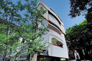 A modern building with a white facade, large windows, and a sign indicating affiliation with a university.