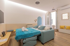 Ein modernes Hotelzimmer mit Bett, Sitzgelegenheit und Schreibtisch.
