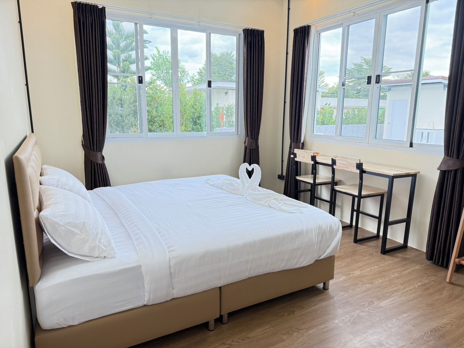 Quarto com cama, escrivaninha e duas cadeiras.