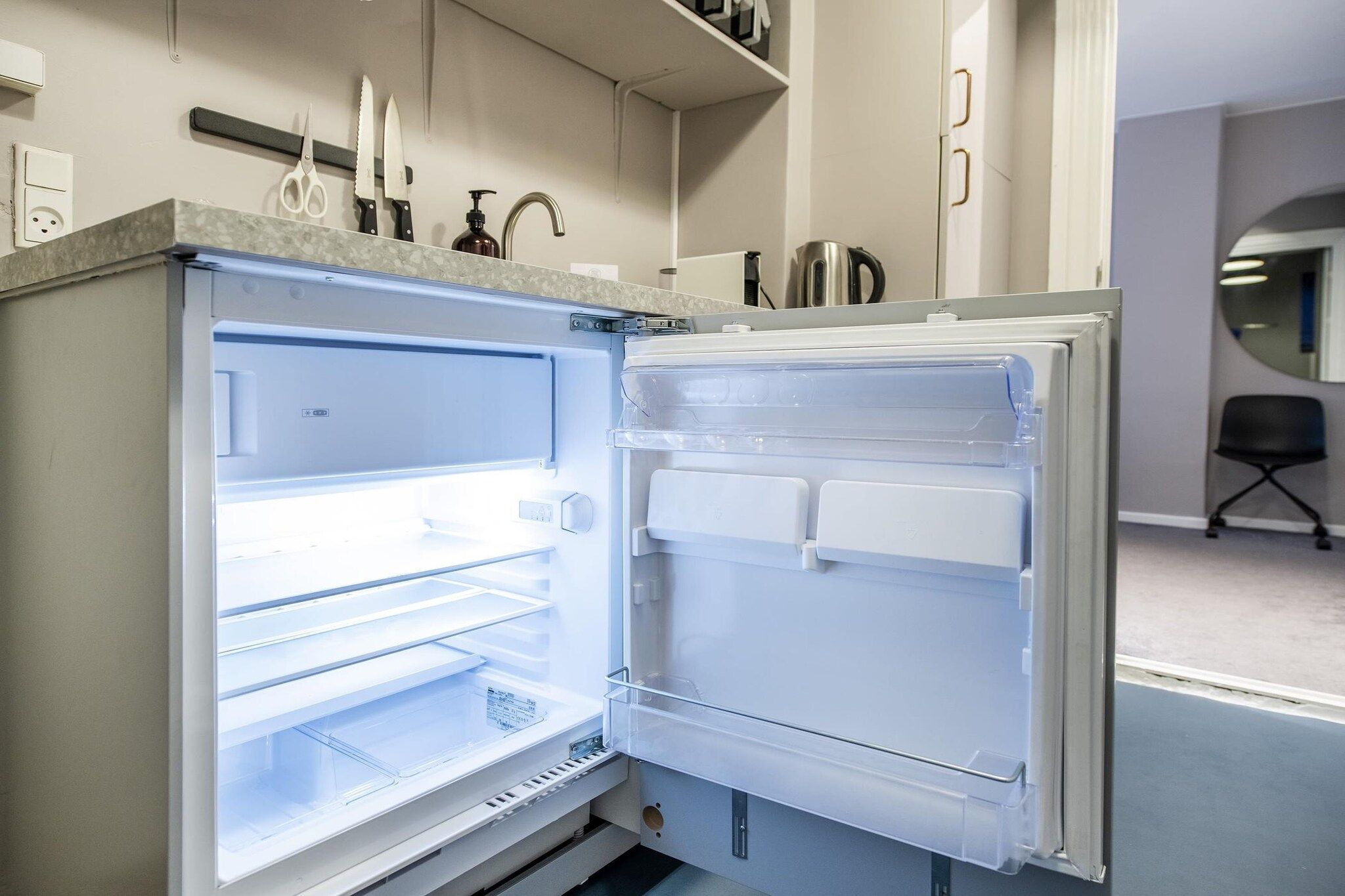 An open refrigerator with multiple shelves and a freezer compartment.