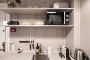 A kitchen with a microwave, sink, and various utensils. - Flat Near Copenhagen Canals (København)