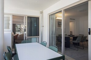 A modern interior with a conference table, chairs, and a glass door leading to another room. - Manly Beachfront 3BR, walk to cafes & dining (Manly)