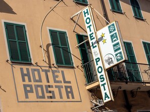 A building with a sign that reads 'HOTEL POSTA' and another sign indicating '24/24' and 'WiFi' availability. - Hotel Posta  (Ventimiglia)