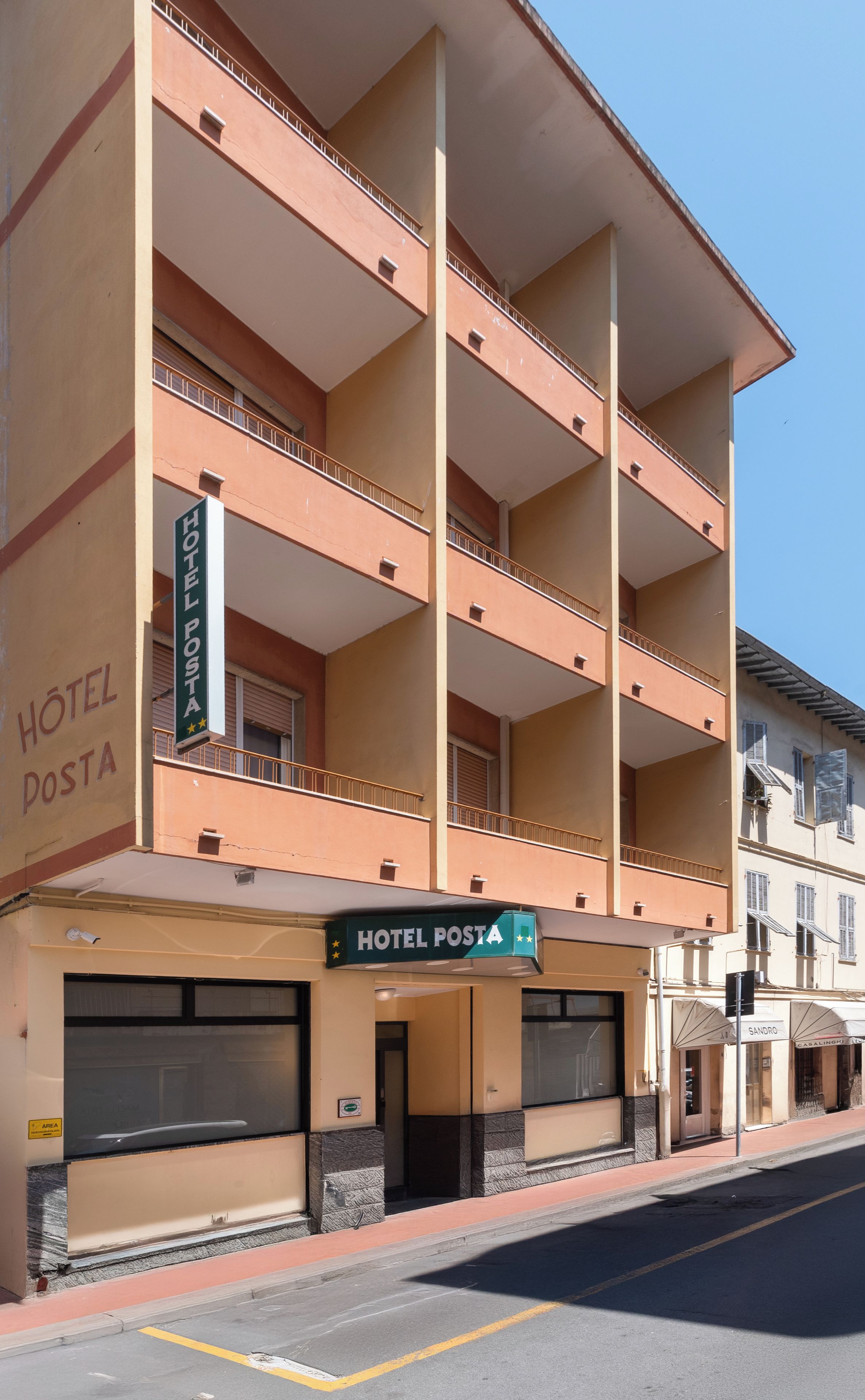 Un edificio de hotel de varios pisos con balcones y un letrero que indica 'HOTEL POSTA'.