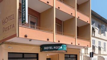 Un edificio de hotel de varios pisos con balcones y un letrero que indica 'HOTEL POSTA'.