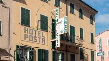 Un hotel con un cartello che indica una reception aperta 24 ore su 24 e una vetrina ben visibile del negozio 'MIDA BIJOUX'.