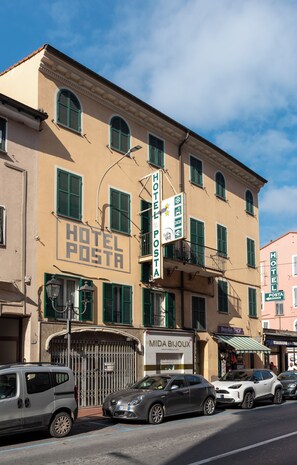 A hotel with a sign indicating a 24-hour reception and a visible storefront for 'MIDA BIJOUX'.