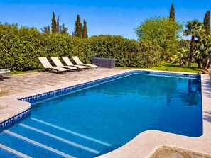A swimming pool with a tiled edge, lounge chairs, and a small shed. - Finca in Santa Magalida With Wifi (Santa Margalida)