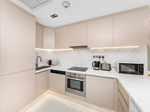 A modern kitchen with a built-in oven, microwave, and kettle. - Kensington Burj View Studio, Dubai Mall (Dubai)