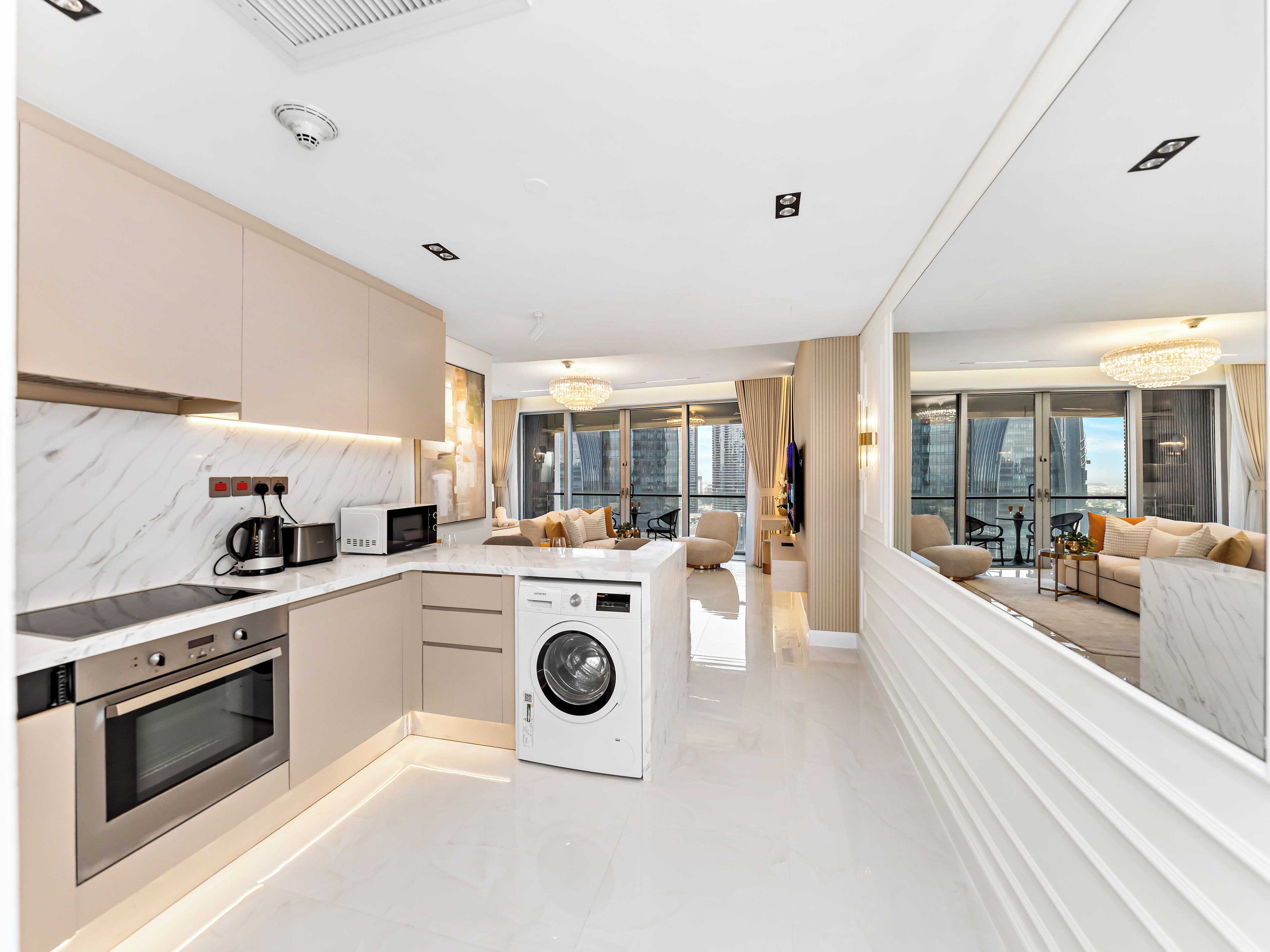 Een moderne keuken met inbouwapparatuur, een centraal eiland en een groot raam.
