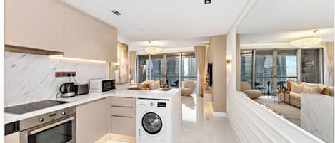 A modern kitchen with built-in appliances, a central island, and a large window.
