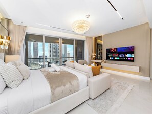 A modern bedroom with a large bed, a TV mounted on the wall, and a city view. - Kensington Burj View Studio, Dubai Mall (Dubai)