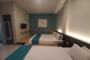 A hotel room with a bed, a TV on the wall, and a painting above the bed. - Good Wish Family Suite Escape (Semarang)