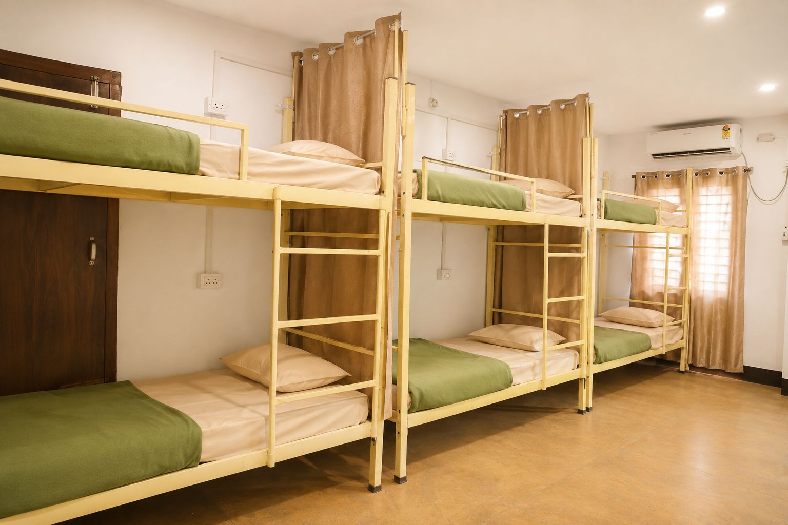 Quarto com beliches, guarda-roupa de madeira, ar condicionado e janela com cortinas.