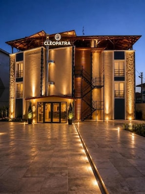 A hotel named 'CLEOPATRA' with a modern architectural design, featuring a prominent entrance with glass doors and a staircase leading to the upper levels. - Pamukkale Cleopatra (Pamukkale)