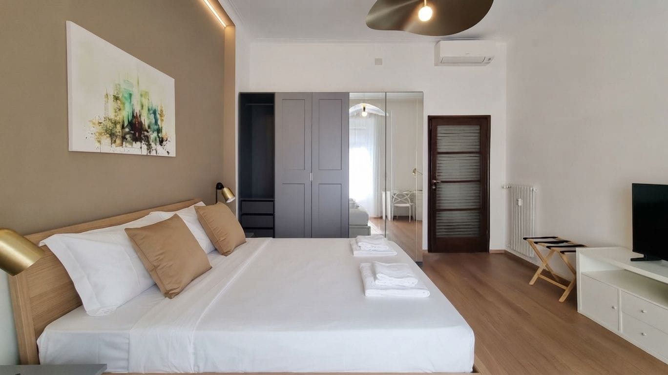 Une chambre d’hôtel avec un grand lit, une télévision, un bureau et un tableau au mur.