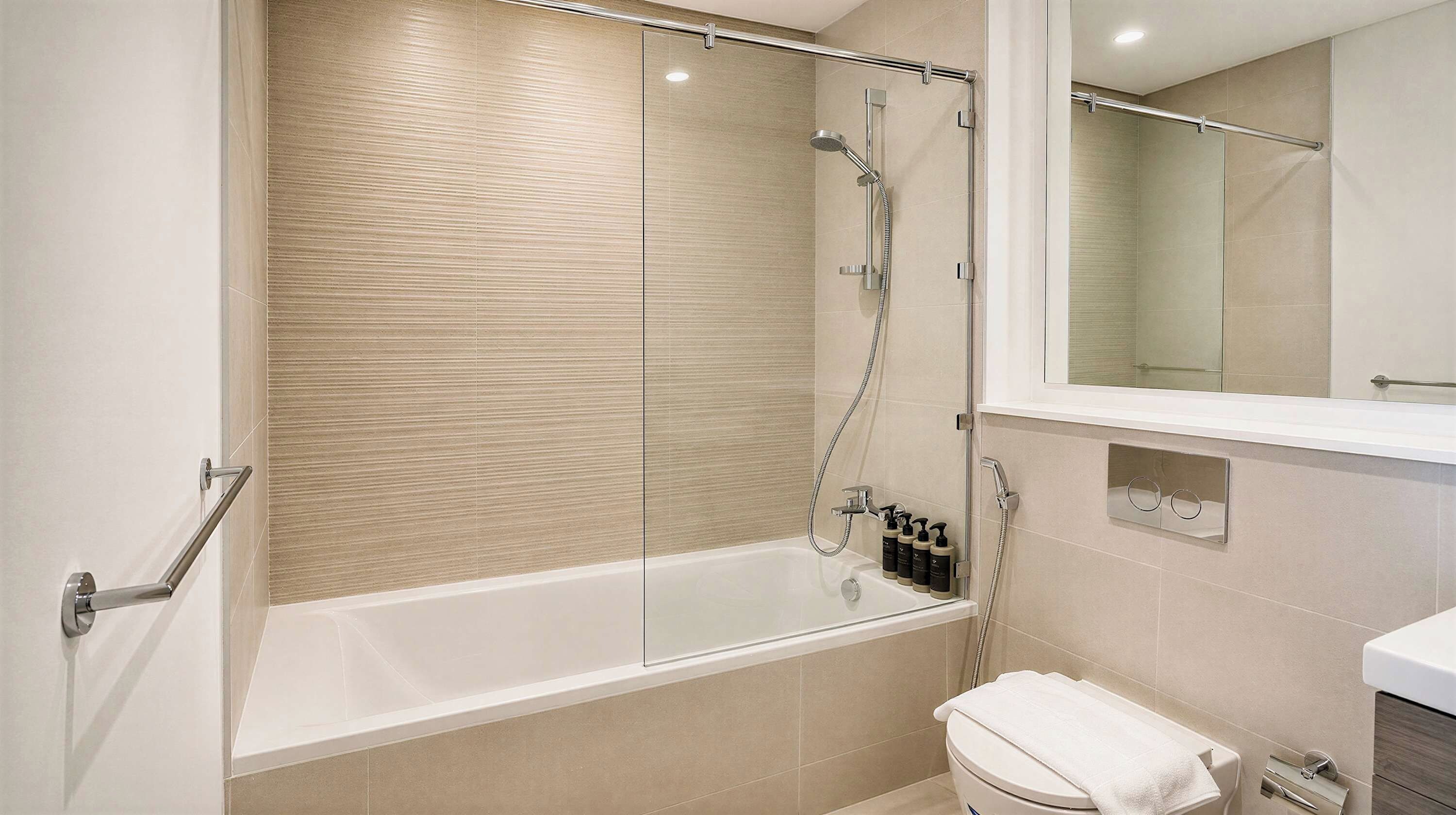 Ein modernes Badezimmer mit einer gläsernen Duschkabine, einer weißen Badewanne und einem sichtbaren WC.