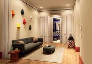 Una sala de estar moderna con sofá, reposapiés y decoraciones de pared coloridas.