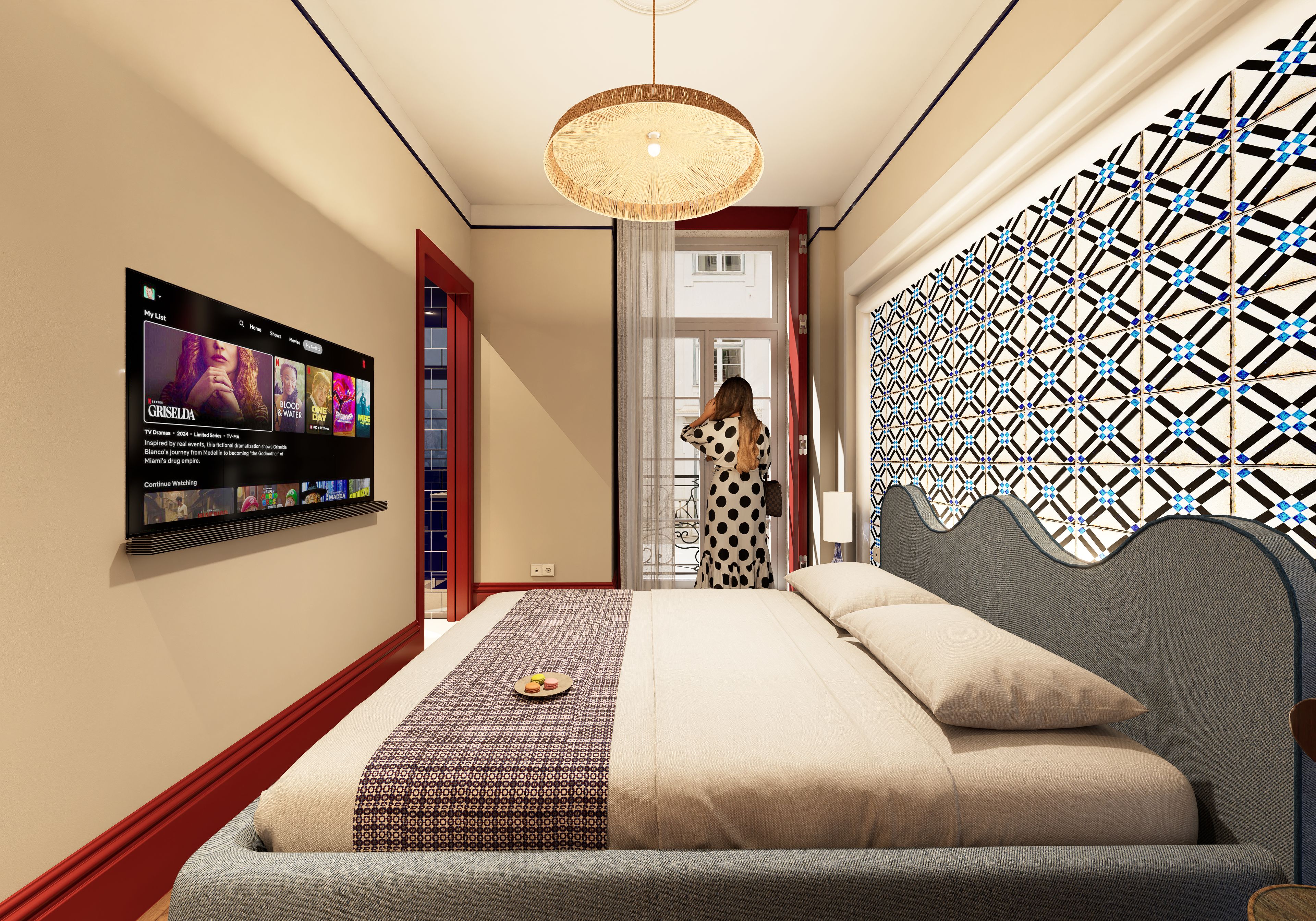 A hotel room with a bed, a wall-mounted TV displaying a movie, and a patterned wall.