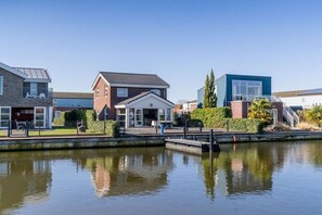 A residential area with a canal, houses, and a small bridge. - Holiday home with 3 bedrooms (Oude-Tonge)