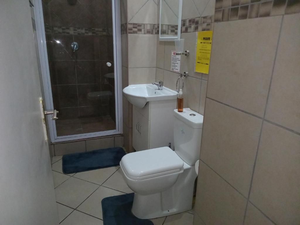 A small bathroom with a shower, toilet, and sink.