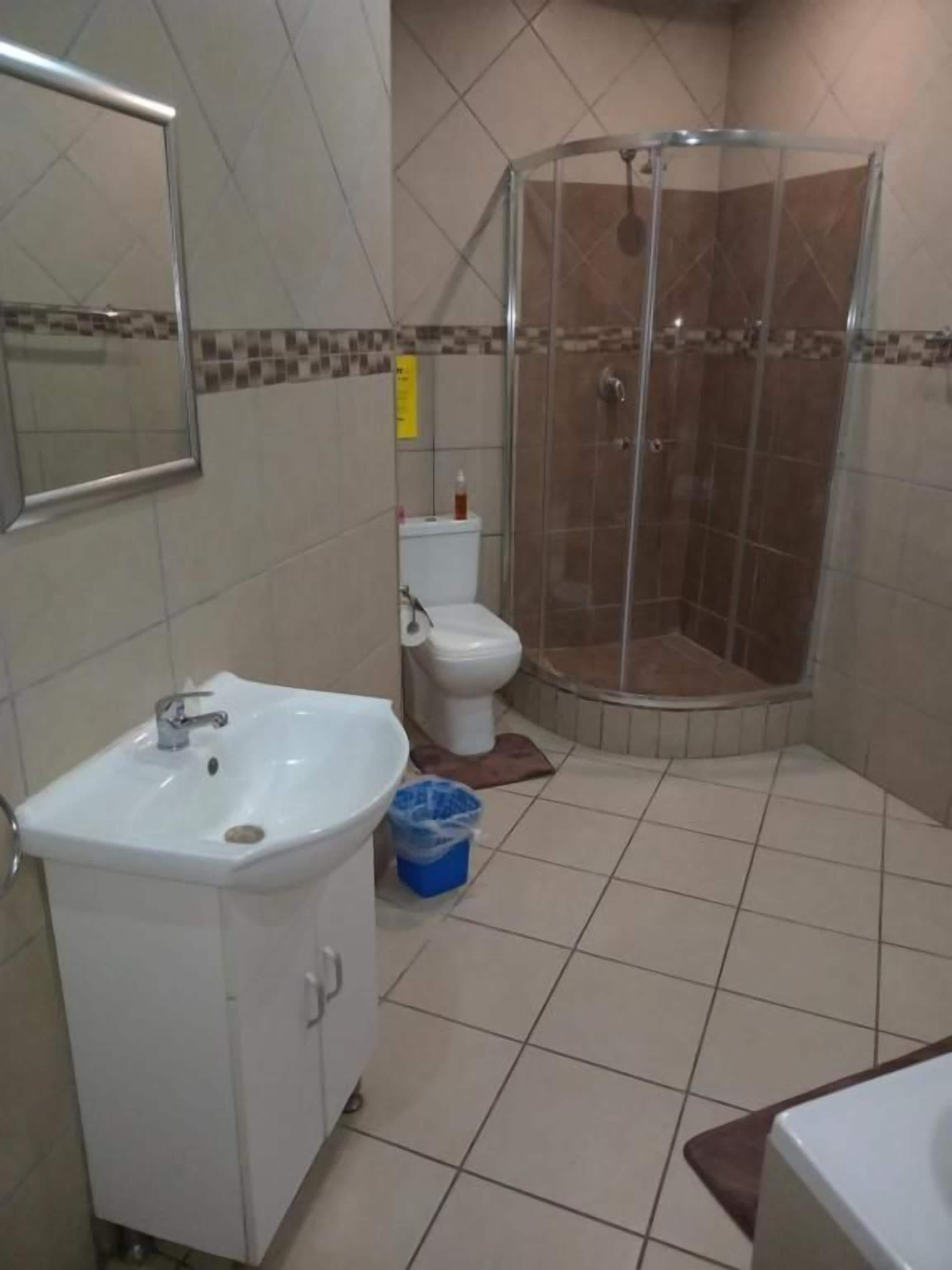 Un baño con lavamanos, inodoro y ducha.
