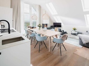 A modern interior with a dining area, kitchen, and living space. - Meer.loft.juist.9 (Juist)