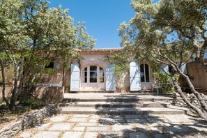 A building with a tiled roof, a central arched doorway, and a stone staircase leading to the entrance. - Holiday home in Joucas with swimming pool (Joucas)