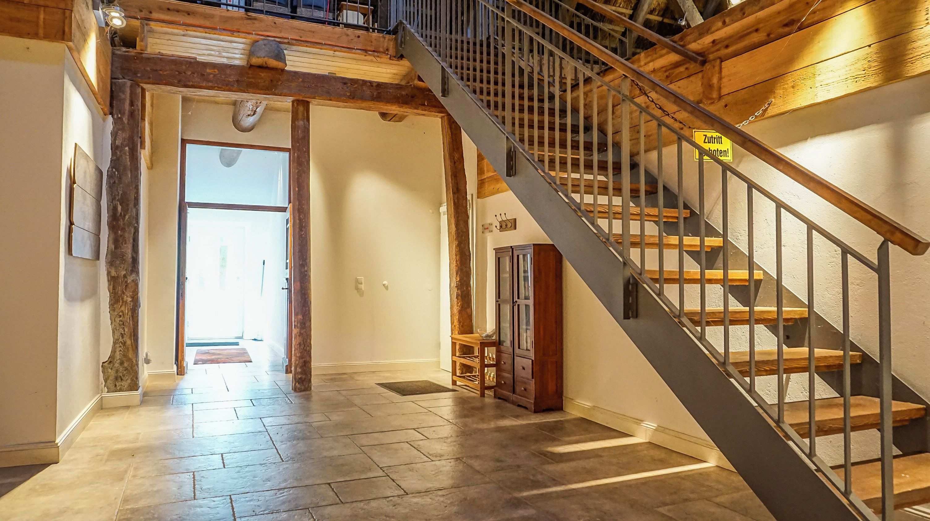 A staircase with a metal railing leading to an upper floor.
