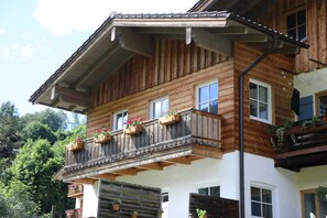 Un edifici de fusta de diversos pisos amb balcons, finestres i un teulat inclinat.