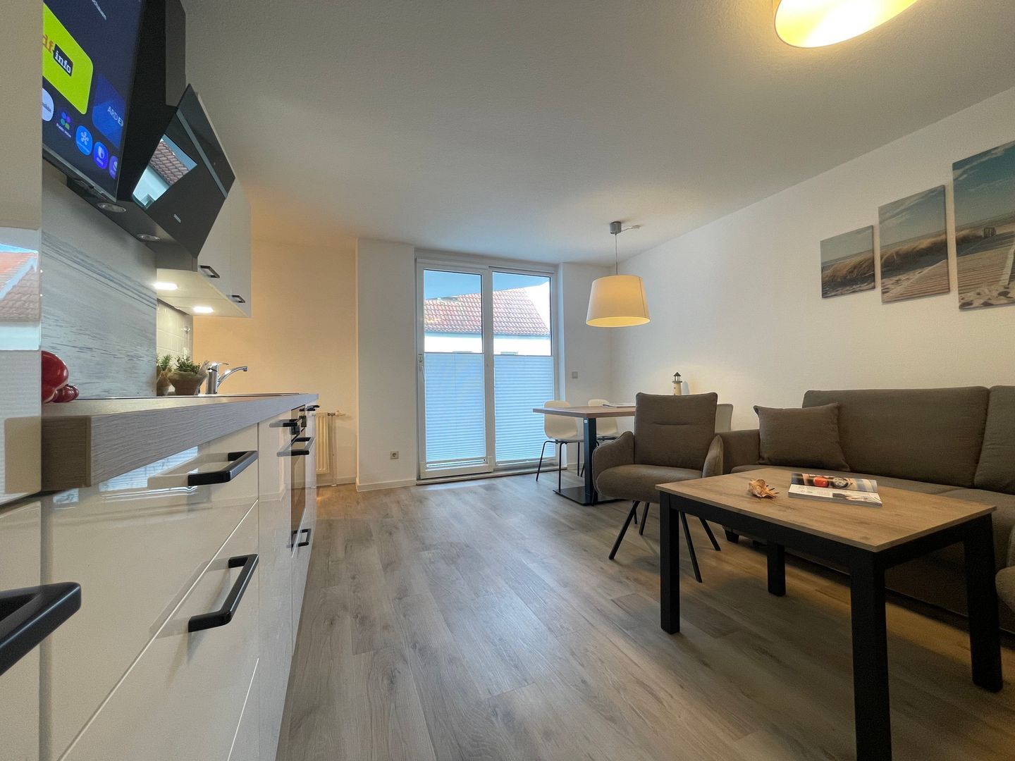 En moderne lejlighed med køkken, spiseområde og opholdsstue.