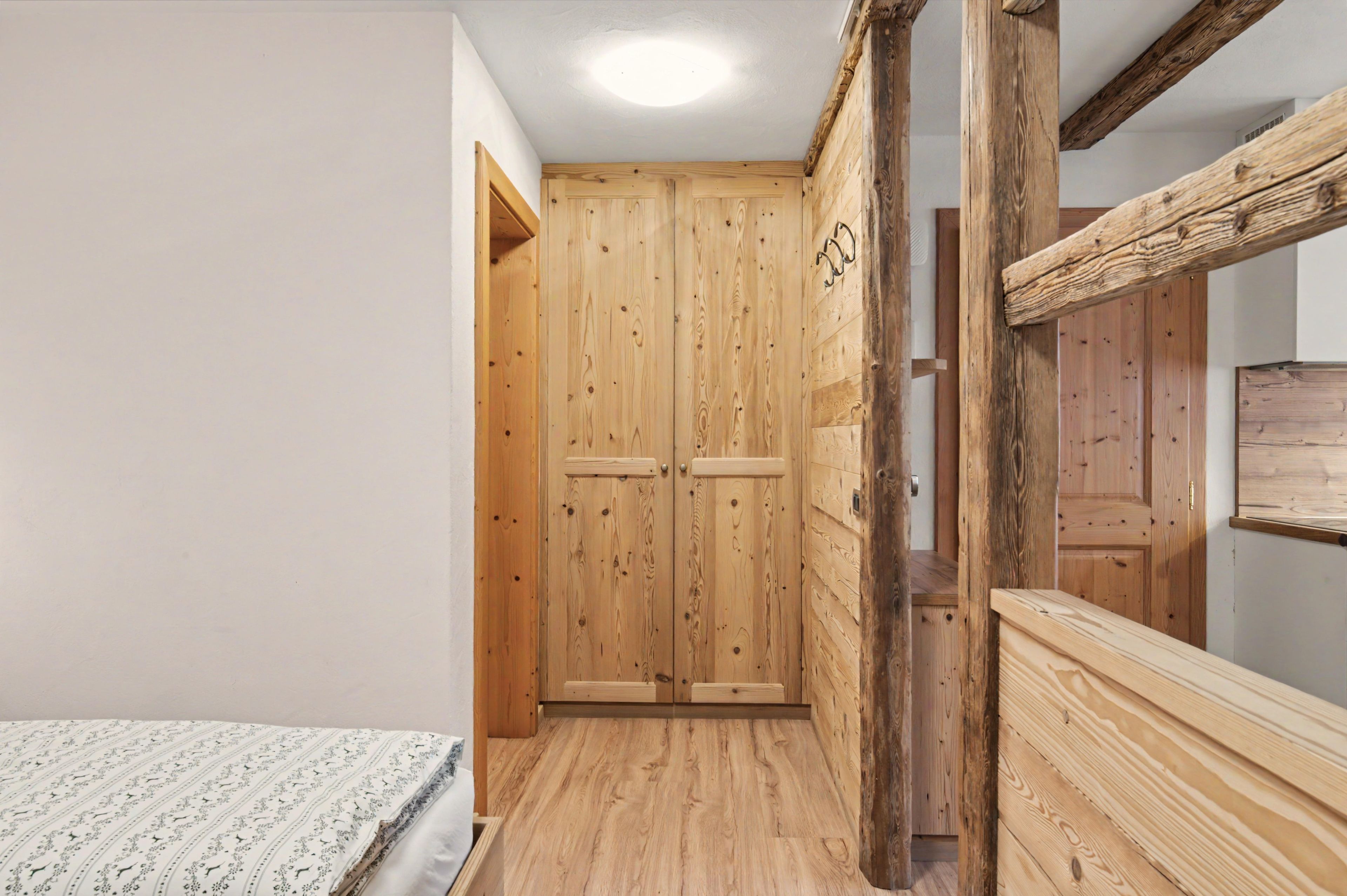 A narrow hallway with wooden walls and a wooden door.
