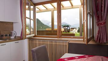 Habitación con vista a una terraza y montañas, un radiador, un lavamanos y una silla.