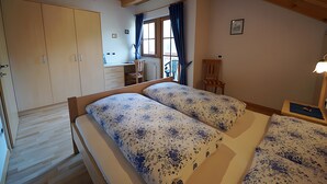 Una camera da letto con un letto matrimoniale, un armadio, una scrivania e una sedia.
