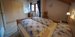 A bedroom with a double bed, a wardrobe, a desk, and a chair. - Apartment 'Wirthof  1' with Mountain View, Shared Terrace and Wi-Fi (La Valle)