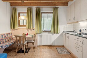 Una cocina compacta con comedor, techo de madera y radiador.
