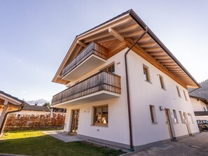 A two-story residential building with a balcony on the upper floor, a garage, and a well-maintained lawn. - Anuk House Holiday Home With Mountain Views (Farchant)