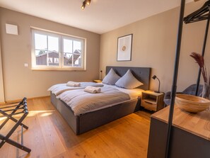 A bedroom with a large bed, a window, a bedside table, and a nightstand. - Anuk House Holiday Home With Mountain Views (Farchant)