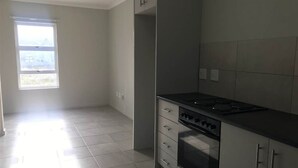 Una cocina con estufa, horno y alacenas.