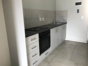 Una cocina con estufa, horno y pileta.