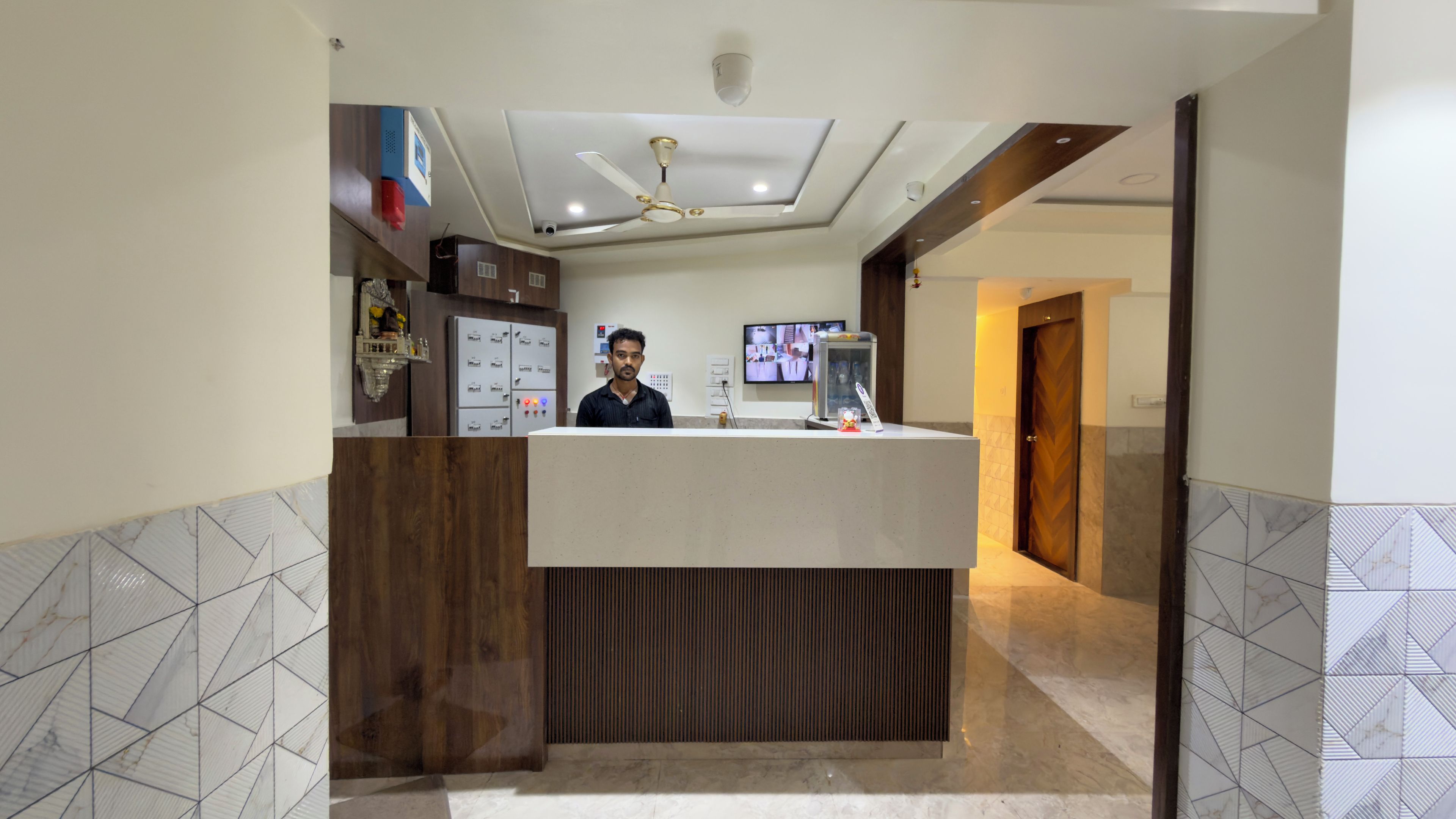 A reception desk with a modern design, a ceiling fan, and a television screen.