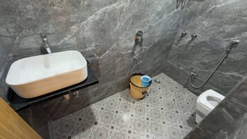 A bathroom with a white sink, a toilet, and a shower area.
