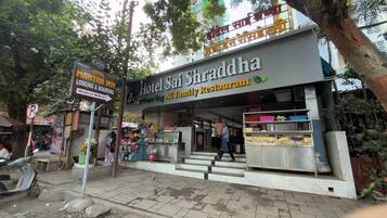 A hotel with a signboard for Hotel Sai Shraddha AC Family Restaurant.