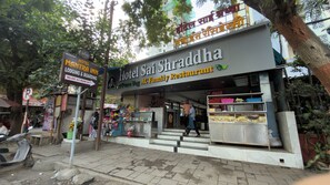 Un hôtel avec une enseigne indiquant « Hôtel Sai Shraddha, restaurant familial climatisé ».