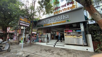 A hotel with a signboard for Hotel Sai Shraddha AC Family Restaurant.