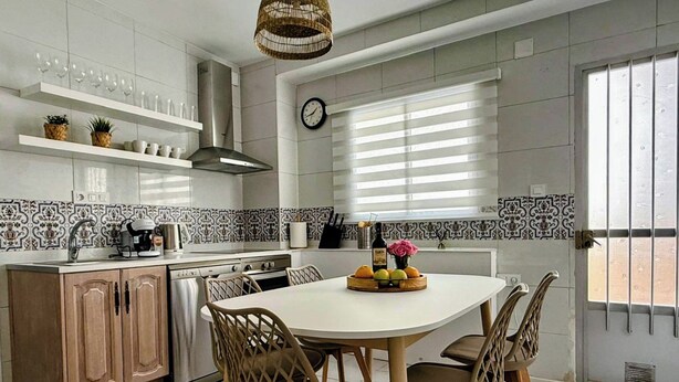 A modern kitchen with a round dining table, wooden chairs, and a variety of kitchen appliances. - Spacious family home with 4 bedrooms and 2 terraces, just minutes from the A92 Autovia (Loja)