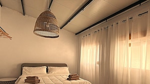 A bedroom with a bed, white curtains, and a hanging light fixture. - Spacious family home with 4 bedrooms and 2 terraces, just minutes from the A92 Autovia (Loja)