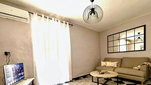 A living room with a checkered floor, a sofa, a coffee table, a TV, and a ceiling fan. - Spacious family home with 4 bedrooms and 2 terraces, just minutes from the A92 Autovia (Loja)