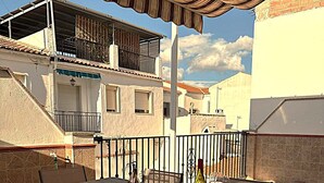 An outdoor patio with a table set for two, a bottle of wine, and a glass. - Spacious family home with 4 bedrooms and 2 terraces, just minutes from the A92 Autovia (Loja)